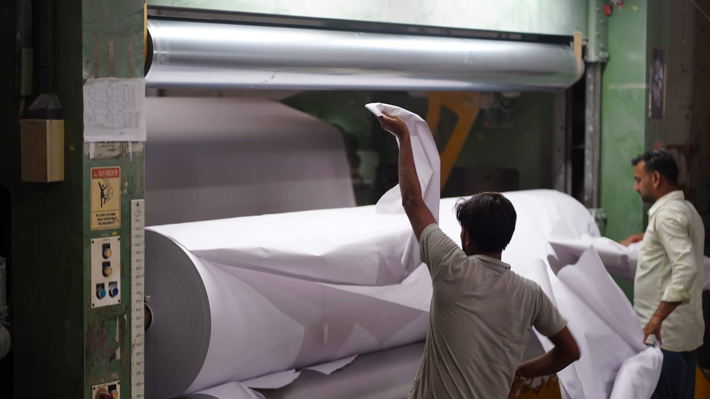 Operator checking the sheet surface as the finished reel turns